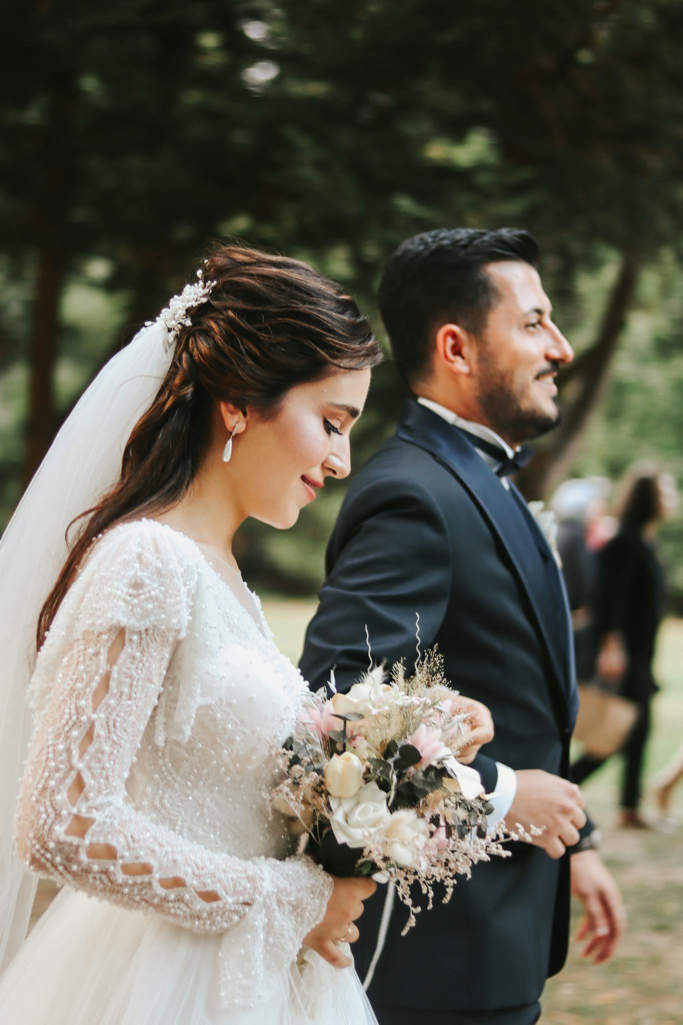 Bride and groom walking joyfully during an outdoor wedding ceremony.